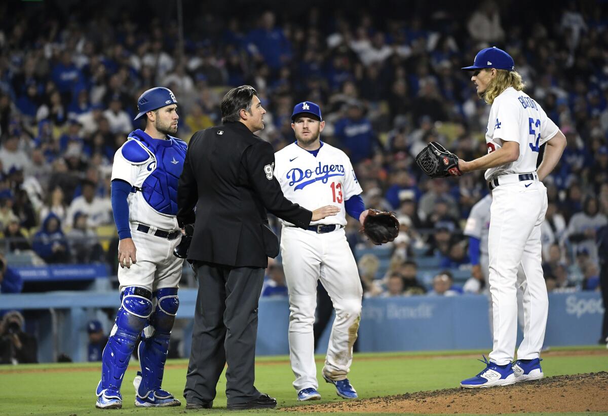 Umpire Mark Ripperger talks with Dodgers players.