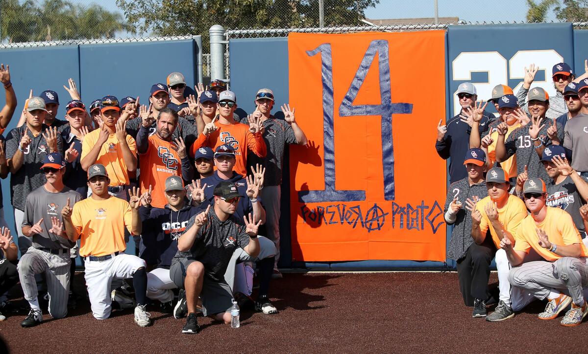 Orange Coast College players and coaches gather around a banner at the school’s baseball field on Jan. 27 to honor head coach John Altobelli, who died with his wife, Keri, and his daughter, Alyssa, in Sunday’s helicopter crash in Calabasas that also claimed the lives of Lakers great Kobe Bryant and five others.