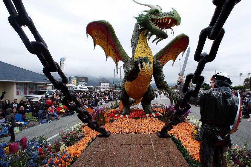 Lindsey Beckmeyer, dressed as a knight, faces a dragon while riding on the Rose Parade float from the city of Torrance on Monday. Beckmeyer came up with the design concept for the float.
