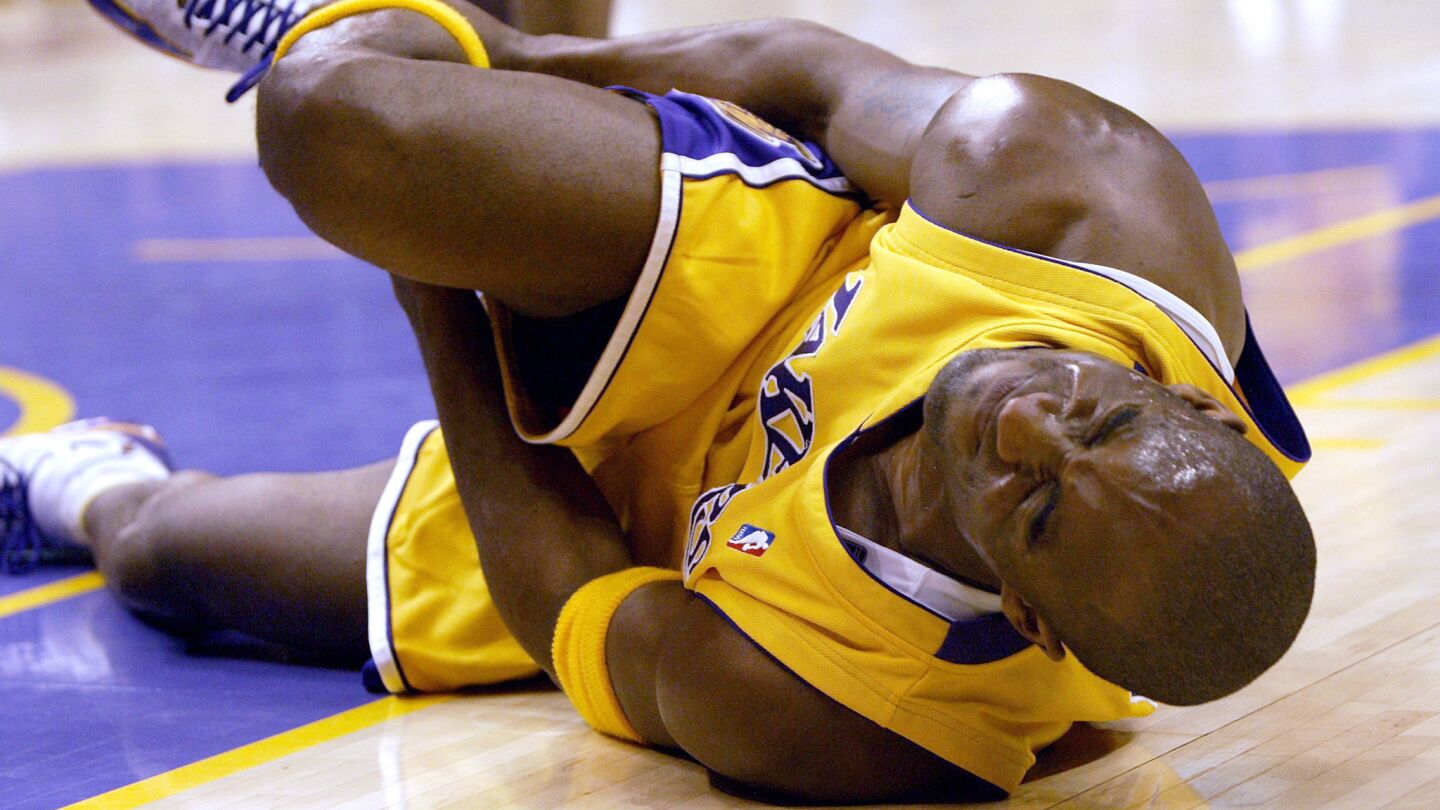 Lakers star Kobe Bryant writhes in pain after injuring his right ankle during a game against the Cleveland Cavaliers at Staples Center on Jan. 13, 2005.
