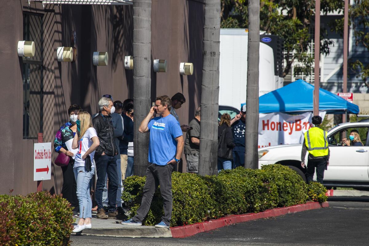 Patrons wait to pick up Easter ham at HoneyBaked Ham in Huntington Beach.