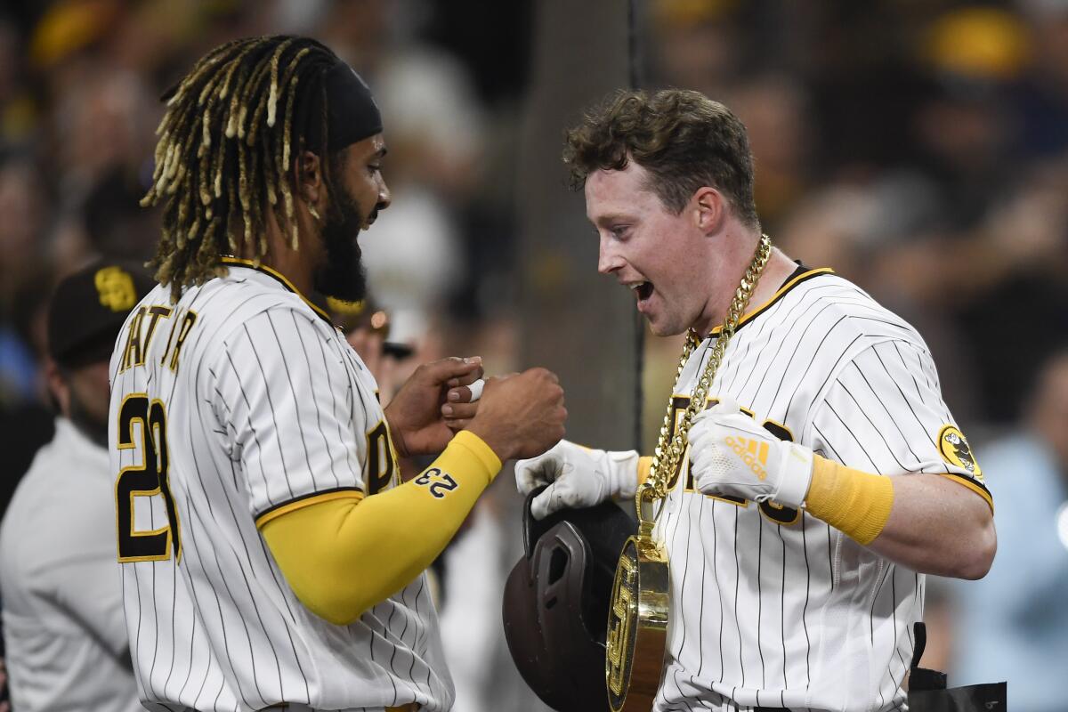 Fernando Tatis Jr. (left) celebrates with Jake Cronenworth after latter hit a solo home run June 25.