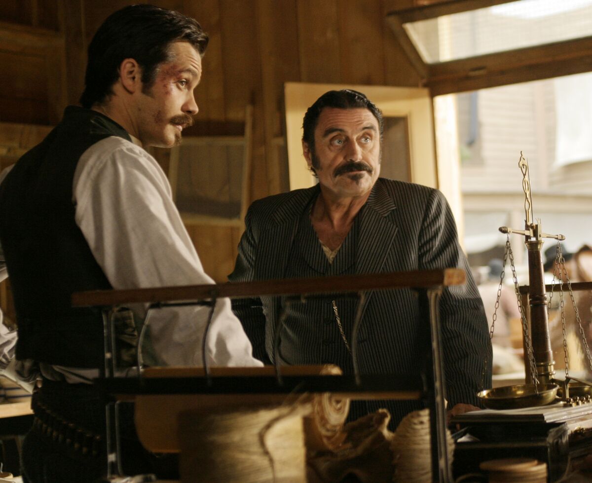 A man with a bruised face and another man standing inside a shop.