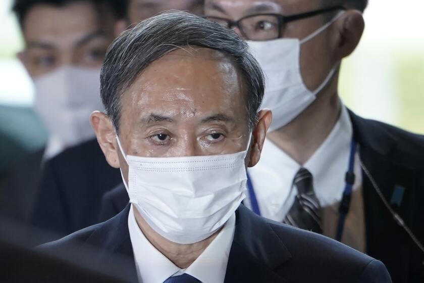 Yoshihide Suga arrives at the prime minister's office after being formally elected Japan’s prime minister in a parliamentary vote, succeeding Shinzo Abe, Wednesday, Sept. 16, 2020, in Tokyo. (AP Photo/Eugene Hoshiko)