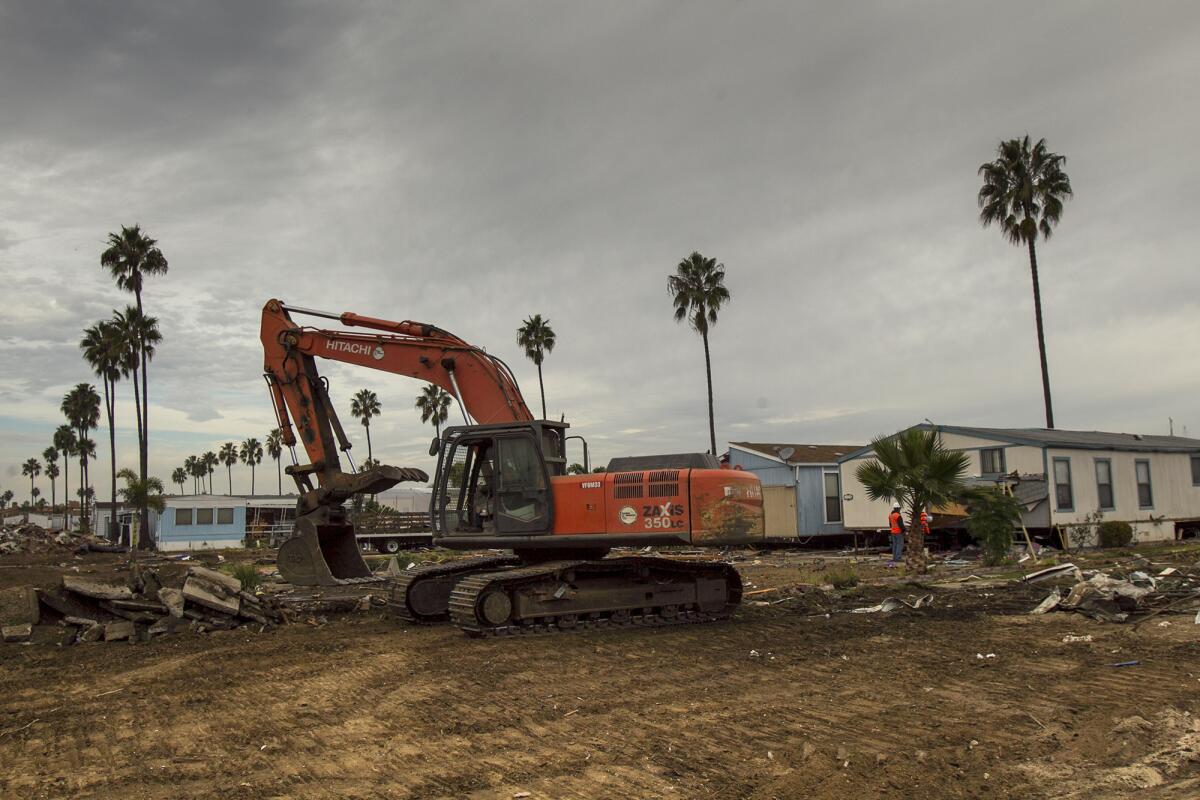 An excavator cleans up debris at the Marina Park mobile home park on Wednesday, December 18. (Scott Smeltzer, Daily Pilot)