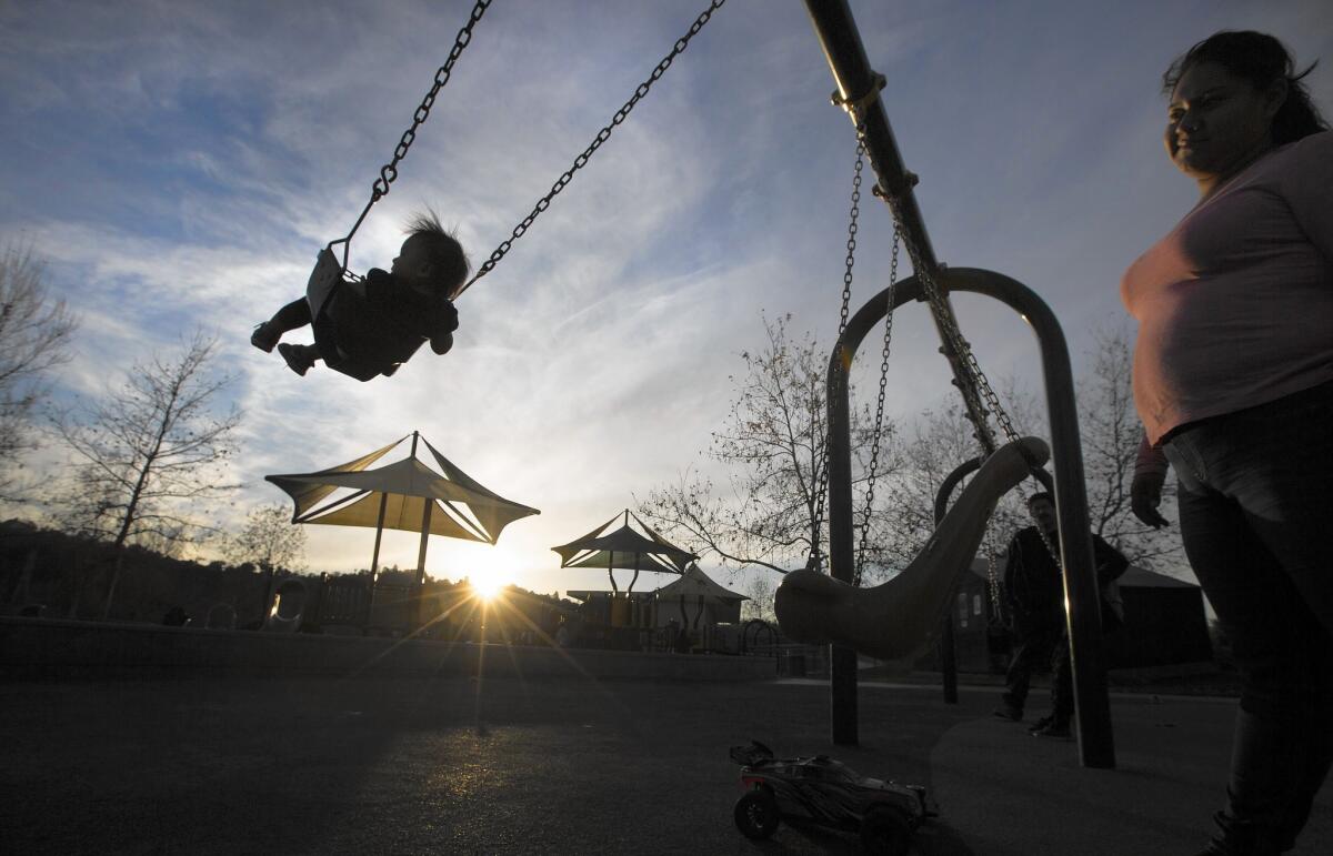 Anahi Gildo pushes her daughter, Aurora, 1, on a swing at Rio de Los Angeles State Park. Southern California hasn't felt the brunt of El Niño-fueled storms that have hit Northern California.