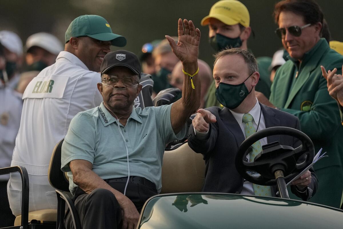 Lee Elder waves as he arrives for the ceremonial tee shots before the first round of the Masters golf tournament