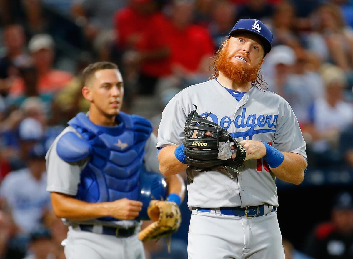 Dodgers third baseman Justin Turner reacts after colliding with catcher Austin Barnes while trying to catch a pop fly.