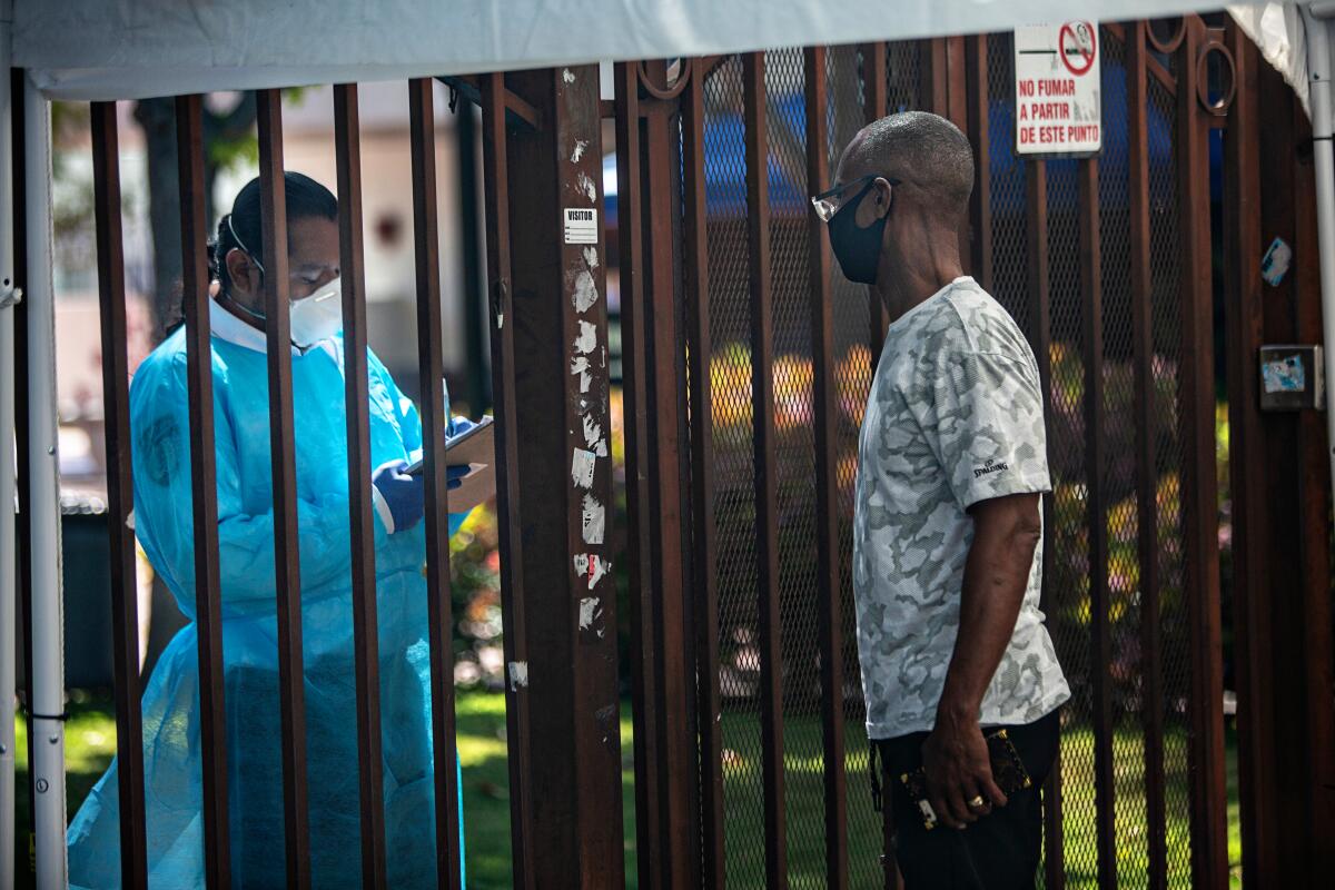 A man talks with a healthcare worker outside Kedren Community Health Center during the coronavirus pandemic in Los Angeles