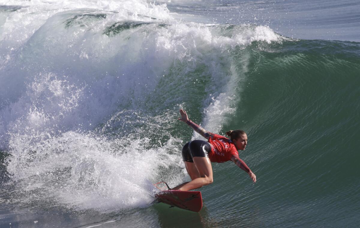 Alyssa Spencer carves a bottom turn while competing in the final of the Nissan Super Girl Surf Pro surf contest.
