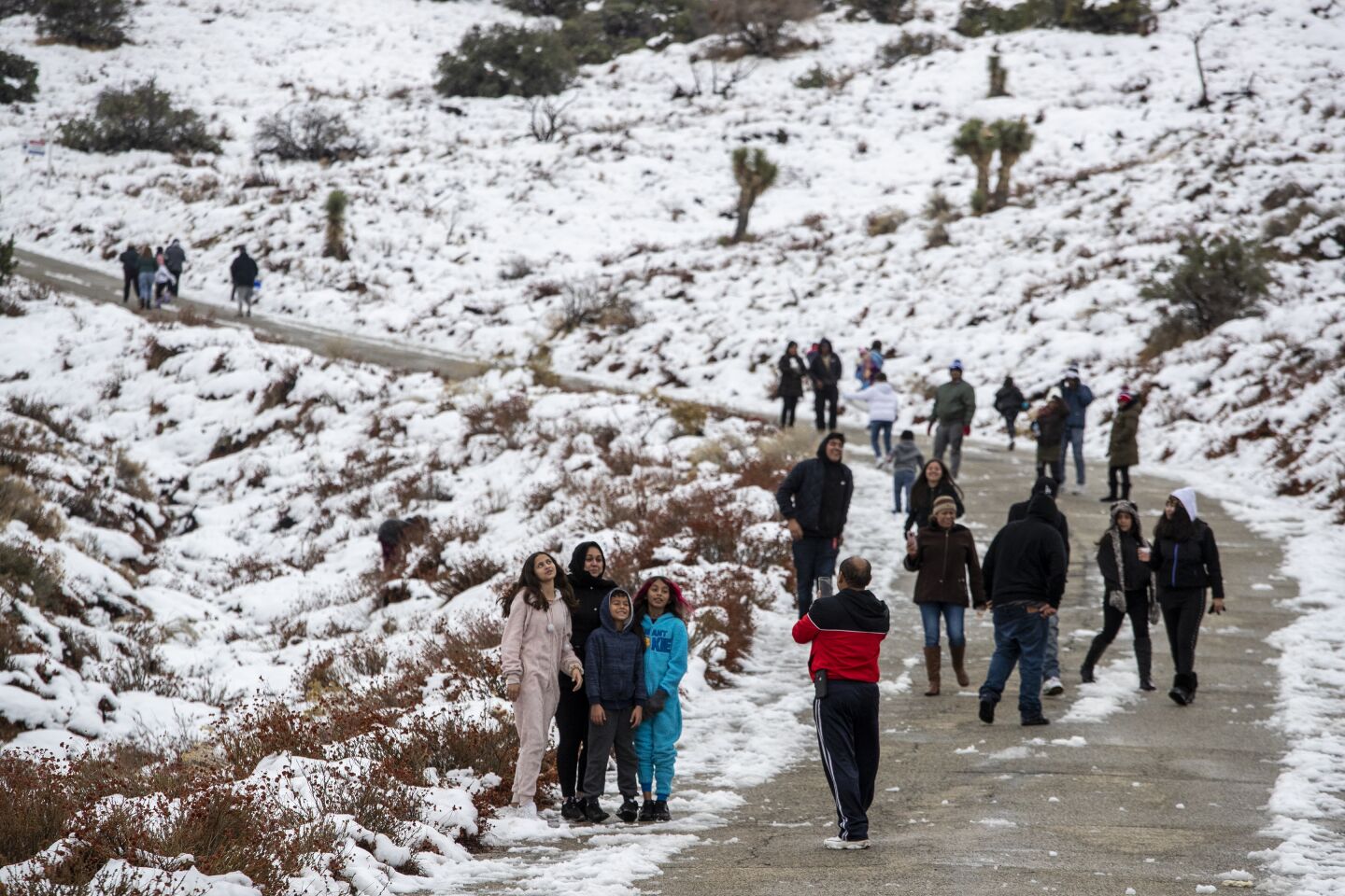 Dozens of people frolic around lingering high desert snow on Tierra Subida Ave. in the Antelope Valley town of Palmdale in Palmdale, Calif., on Dec. 1, 2019.