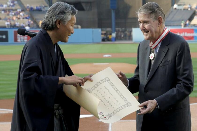 Former Dodgers President Peter O'Malley, right, receives the Order of the Rising Sun from the consul general of Japan in Los Angeles, Harry H. Horinouchi, as part of Japan Night at Dodger Stadium.