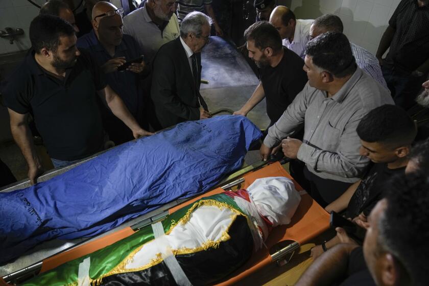 Palestinos se congregan junto a los cuerpos de la turca-estounidense Aysenur Ezgi Eygi, de 26 años, y de Bana Bakr, de 13, en una morgue en Nablús, Cisjordania, el 7 de septiembre de 2024.(AP Foto/Majdi Mohammed)