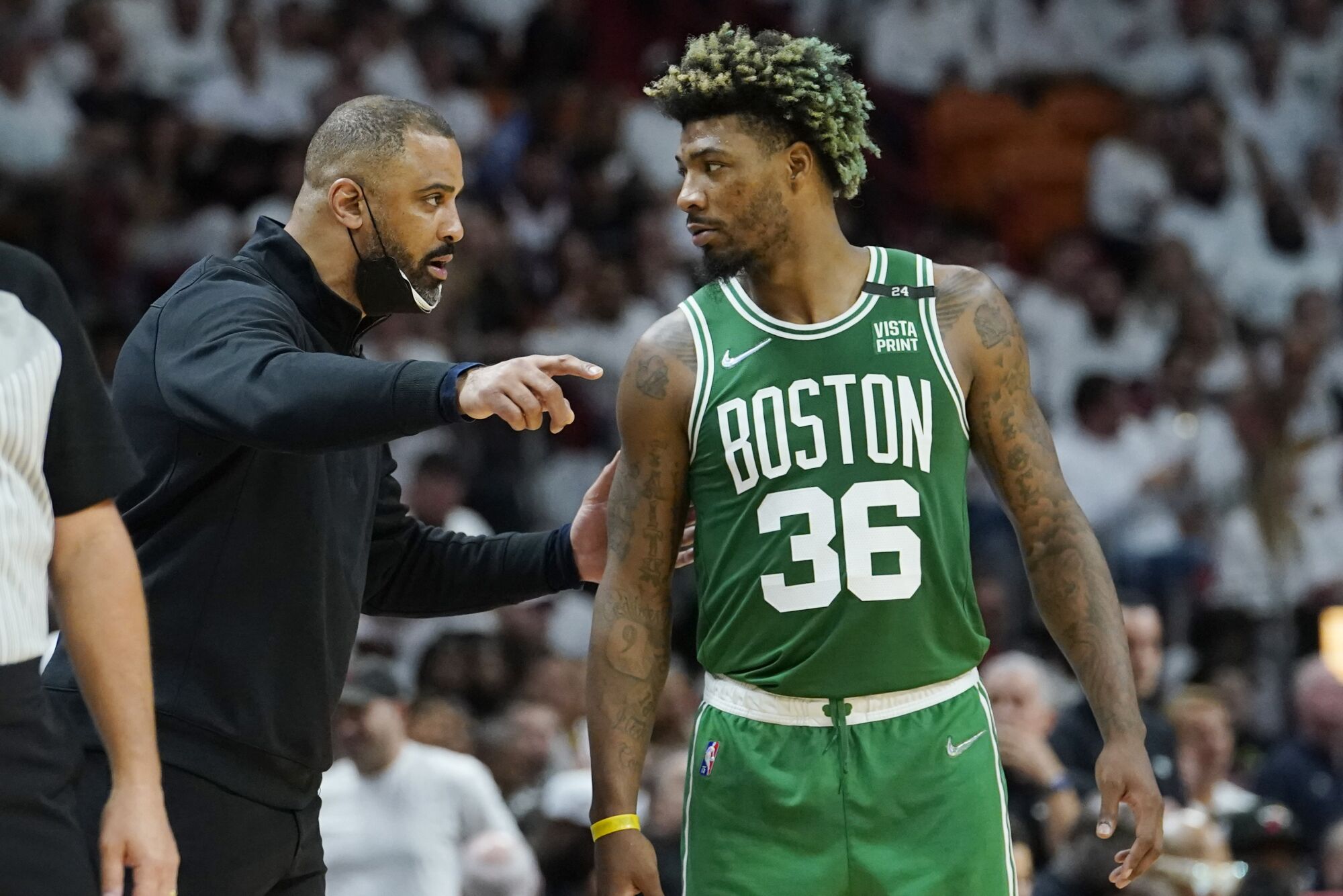 Celtics coach Ime Udoka talks to guard Marcus Smart along the sideline during a break in play.