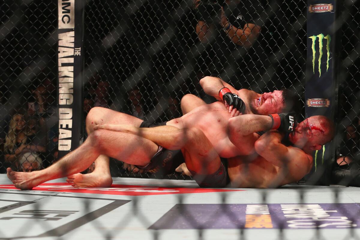 Georges St-Pierre submits Michael Bisping in the third round of their middleweight title bout.