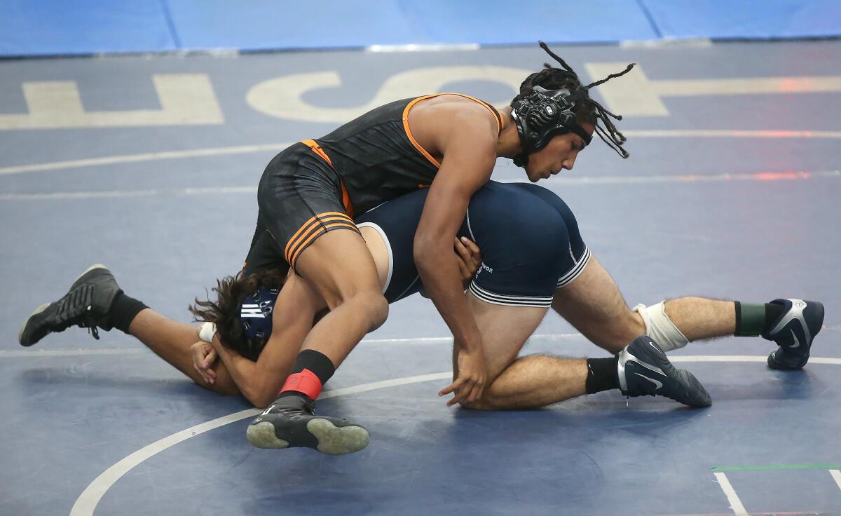 Huntington Beach's Blake DeCourcy, on top, and Newport Harbor's Cole Reynolds battle in a 160-pound match of the Wave League dual meet in Newport Beach on Wednesday.