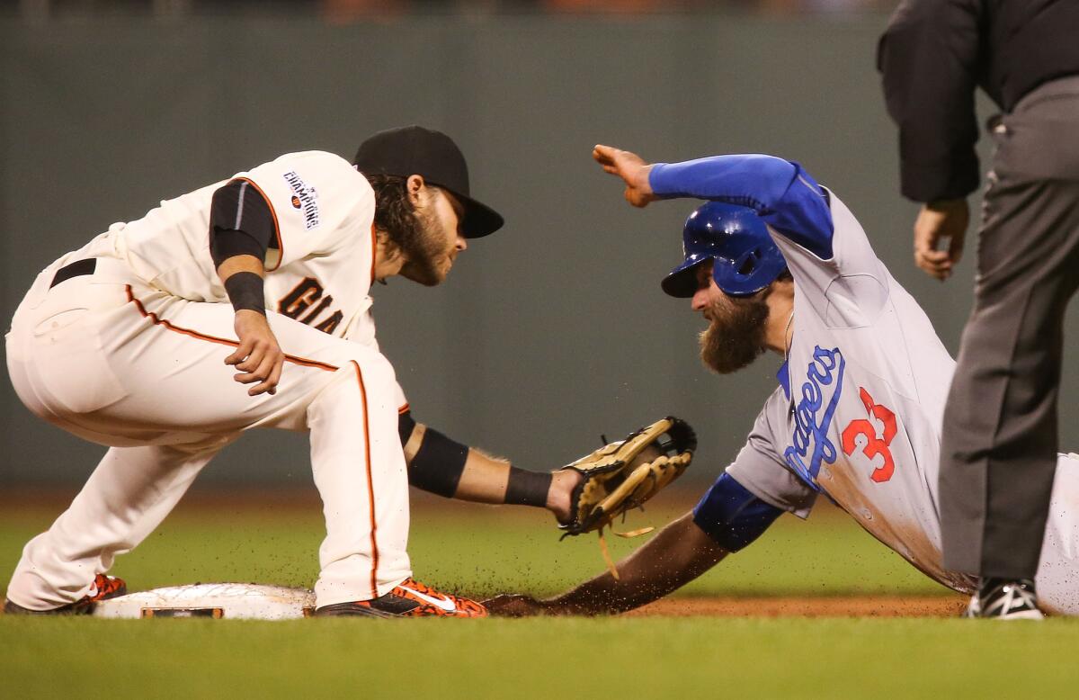 Giants shortstop Brandon Crawford tags out Dodgers outfielder Scott Van Slyke in the top of the eighth innin. The Giants won 2-0.