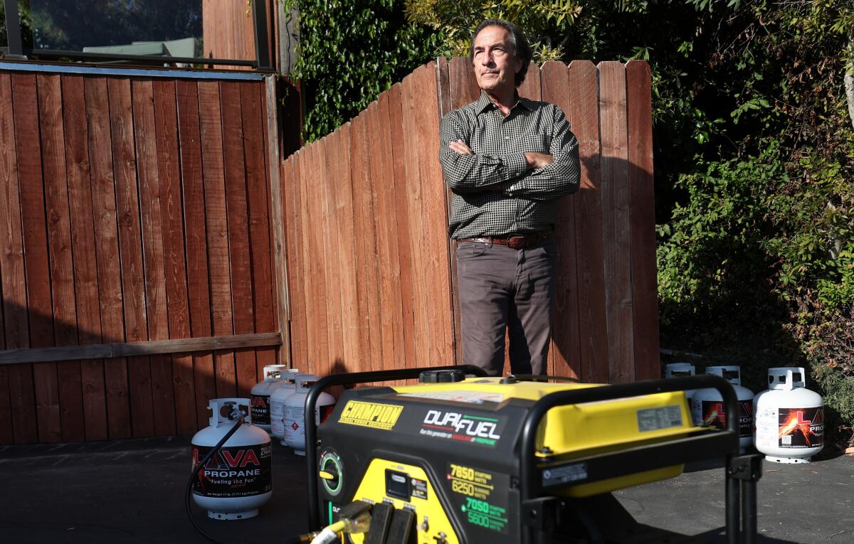 Tom Keefer stands next to a generator outside his house 