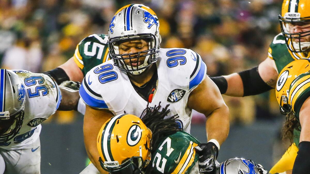 Detroit Lions defensive lineman Ndamukong Suh, top, tackles Green Bay Packers running back Eddie Lacy during the Packers' win Sunday.