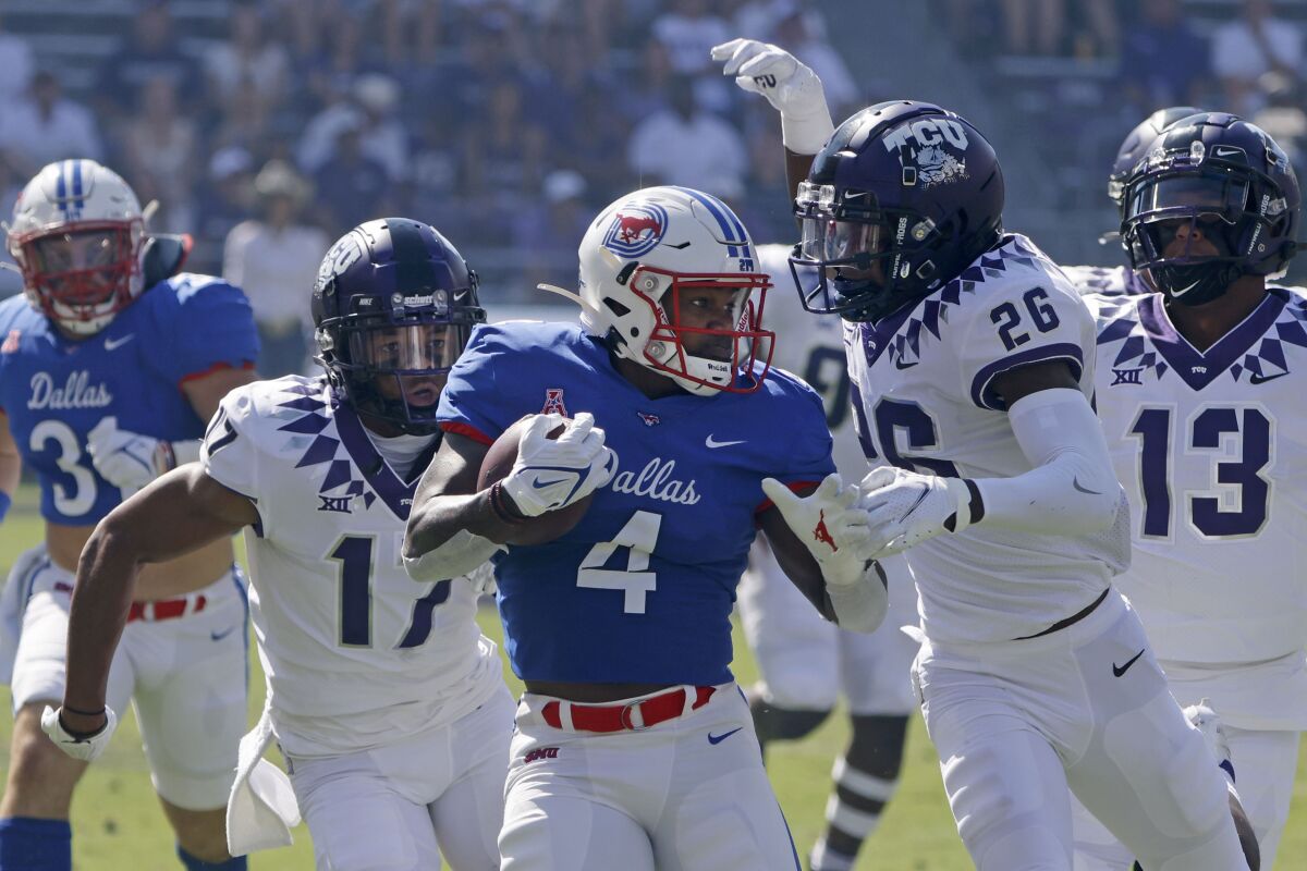 SMU running back Tre Siggers (4) finishes a long run as he is chased by TCU safeties Deshawn McCuin (17) and Christian McDonald (26) during the first half of an NCAA college football game in Fort Worth,Texas, Saturday, Sept. 25, 2021. (AP Photo/Michael Ainsworth)