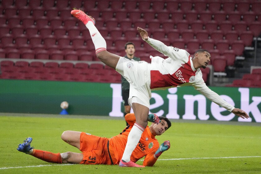 Ajax's Sebastien Haller, top, collides with Sporting's goalkeeper Joao Virginia during a Champions League group C soccer match between Ajax and Sporting CP, at the at the Johan Cruyff ArenA in Amsterdam, Netherlands, Tuesday, Dec. 7, 2021. (AP Photo/Peter Dejong)