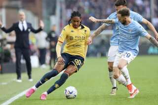 Djed Spence, del Genoa, a la izquierda, disputa un balón con Manuel Lazzari de la Lazio durante el partido del viernes 19 de abril de 2024, en Génova, Italia. (Tano Pecoraro/LaPresse vía AP)