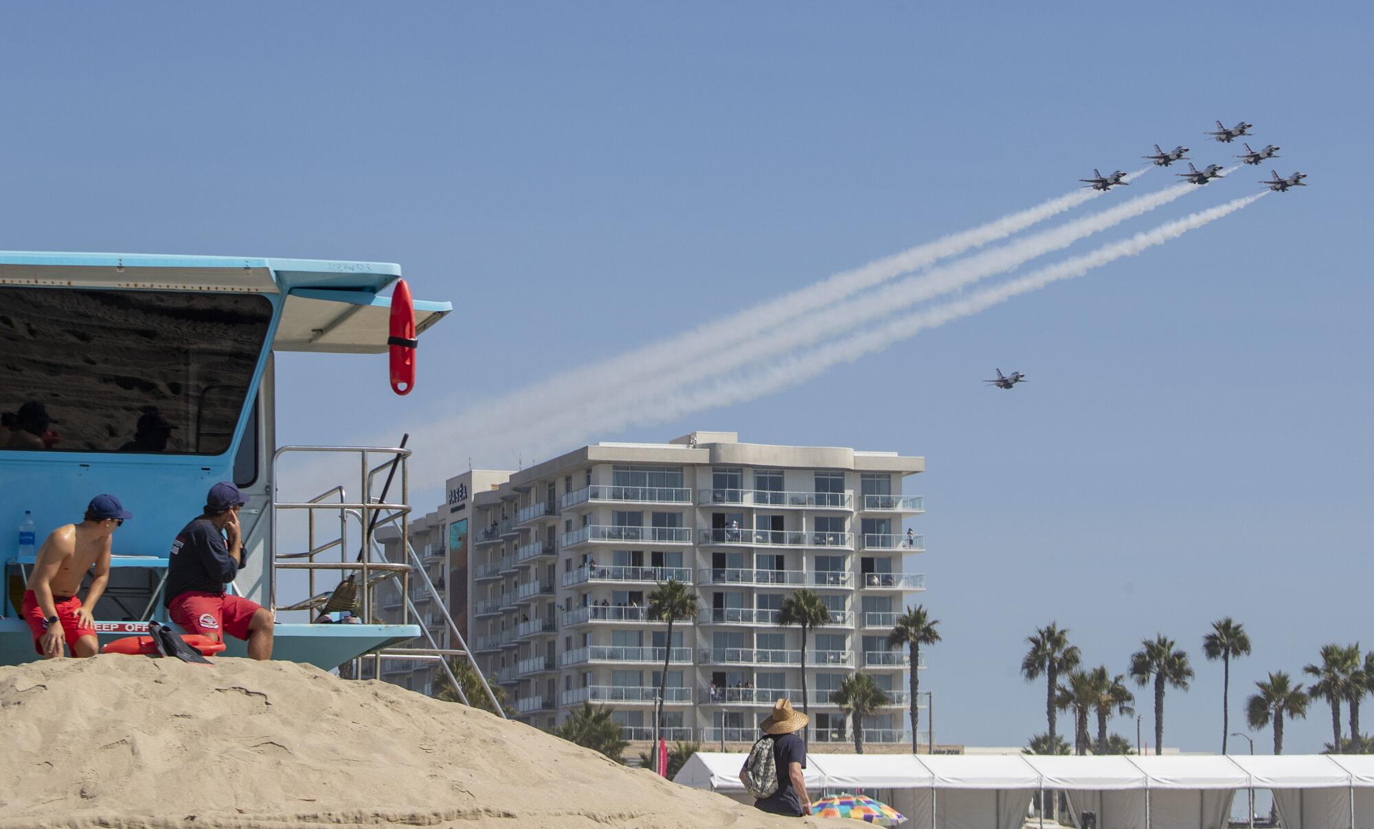  A Huntington Beach lifeguard plugs his ears as the U.S. Air Force Thunderbirds arrive