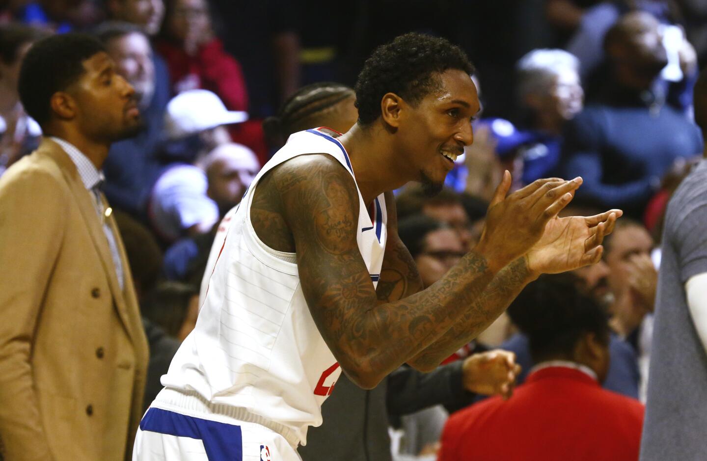 Clippers guard Lu Williams cheers his teammates from the sideline during the closing moments of the fourth quarter of a game Nov. 11 against the Raptors at Staples Center.