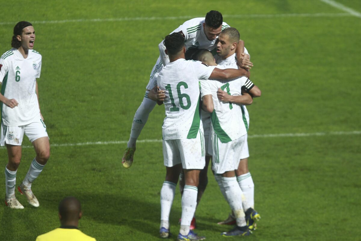 Algeria's Riyad Mahrez is congratulated by teammates after he scored his side opening goal the World Cup 2022 group A qualifying soccer match between Algeria and Burkina Faso at the Mustapha Tchaker stadium in Blida, Algeria, Tuesday, Nov.16, 2021. The match ended in a 2-2 draw. (AP Photo/Fateh Guidoum)
