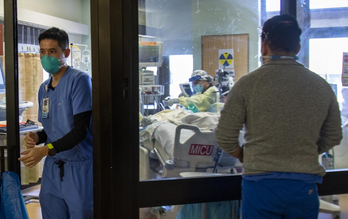 A doctor leaves the room of a COVID-19 patient