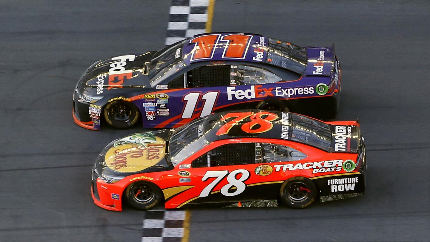 Denny Hamlin in the No. 11 FedEx Express Toyota crosses the Daytona 500 finish line ahead of Martin Truex Jr. in the No. 78 Bass Pro Shops/Tracker Boats Toyota.