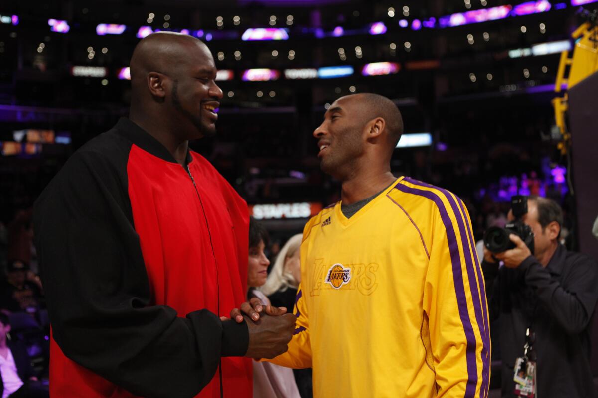 Former Laker Shaquille O'Neal is greeted by Kobe Bryant before a game at Staples Center on Feb. 12, 2013.