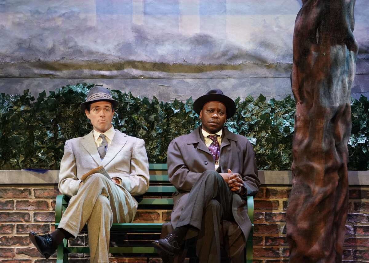 Brendan Hines and Malcolm Barrett, in suits and hats, sit next to each other on a bench in the play "Brushstroke."