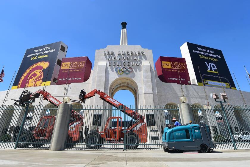 A worker manouevers is vehicle past an entrance to the Los Angeles Coliseum, which played host to the 1932 and 1984 Summer Olympics.