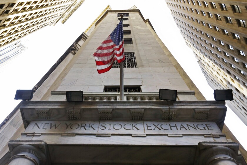 The U.S. flag flies above the Wall Street entrance to the New York Stock Exchange.