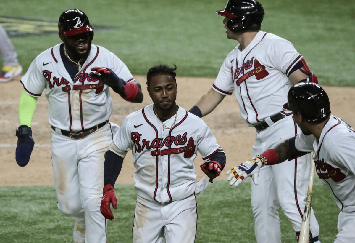 Atlanta Braves second baseman Ozzie Albies, front center, and Marcell Ozuna, left, celebrate with teammates.