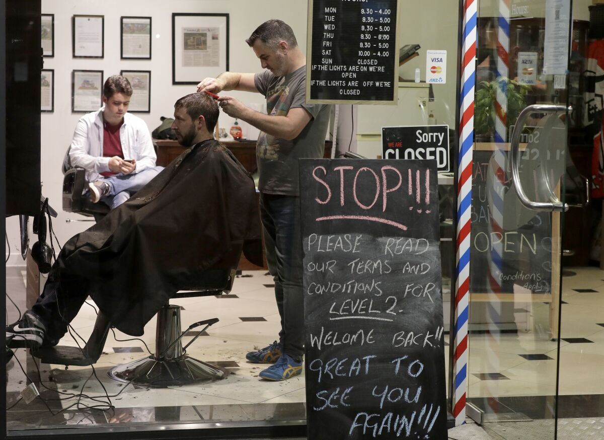 New Zealand barber Conrad Fitz-Gerald cuts the hair of a customer.