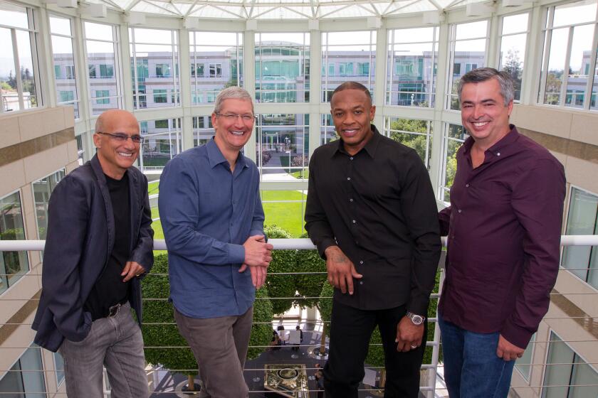 Music entrepreneur and Beats cofounder Jimmy Iovine, left, Apple CEO Tim Cook, Beats cofounder Dr. Dre, and Apple Senior Vice President Eddy Cue at Apple headquarters.