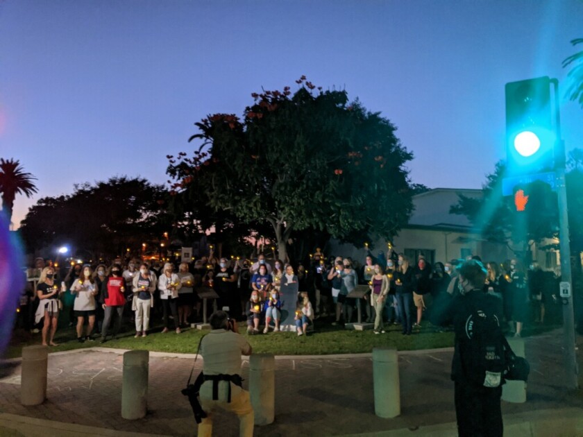 People gather at Triangle Park in Huntington Beach at a candlelight vigil honoring Ruth Bader Ginsburg.
