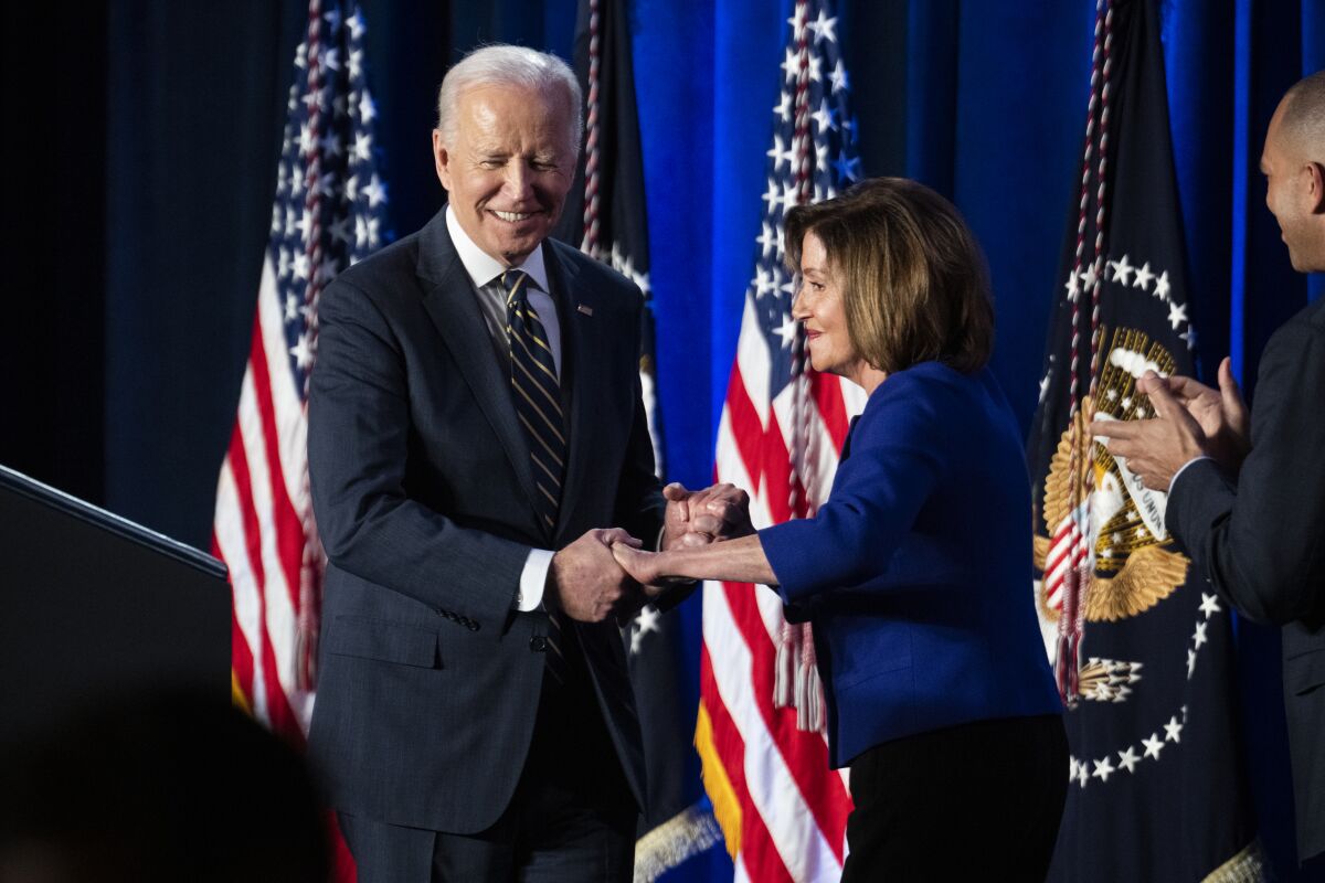President Biden shakes hands with Nancy Pelosi.