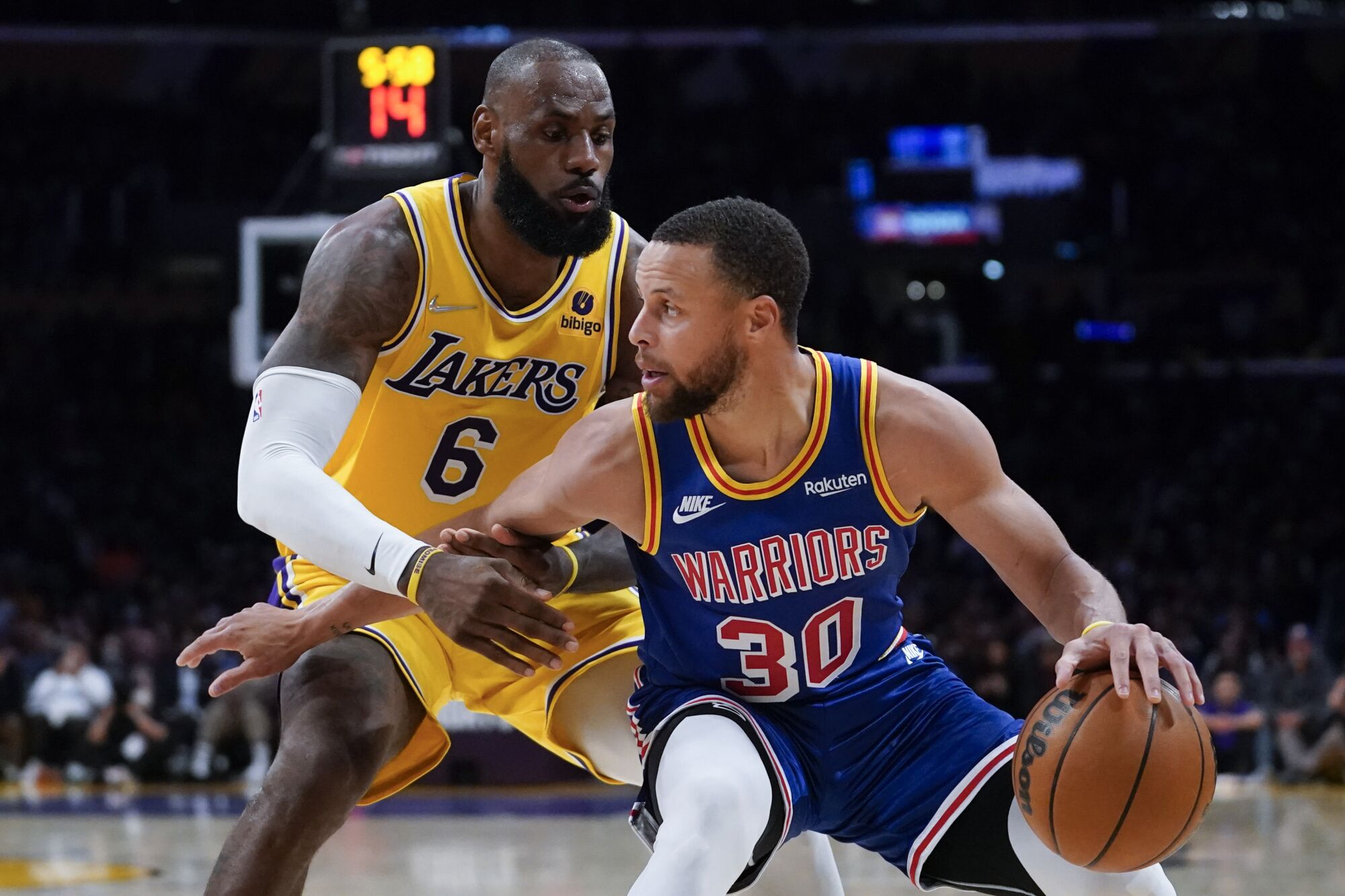 Lakers forward LeBron James pressures Warriors guard Stephen Curry along the baseline.