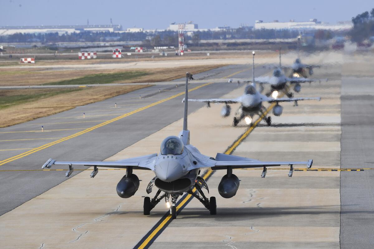 Warplanes lined up for takeoff on a runway