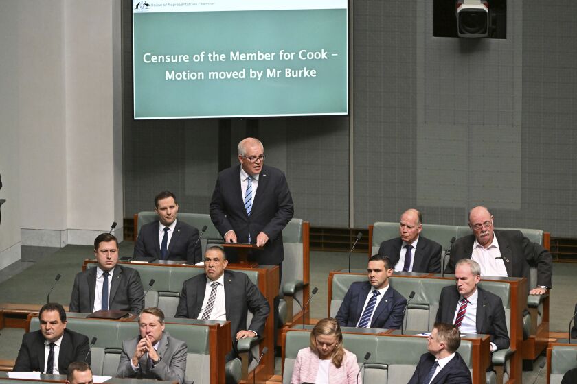 Former Australian Prime Minister Scott Morrison, standing at rear, speaks during a censure motion against him in the House of Representatives at Parliament House in Canberra, Australia, Wednesday, Nov. 30, 2022. Morrison has listed his achievements in government including standing up to a "bullying" China as he unsuccessfully argued against being censured by the Parliament for secretly amassing multiple ministerial powers. (Mick Tsikas/AAP Image via AP)