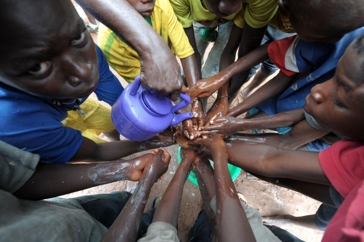 People wash their hands with soap and bleach Sept. 3 to prevent the spread of Ebola in the northern Senegalese city of Diaobe. A separate outbreak in Congo is believed to have killed at least 35 people.