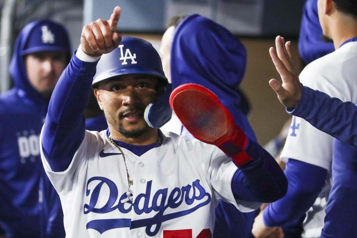 Mookie Betts celebrates in the dugout after scoring a run during the Dodgers' season-opening win.