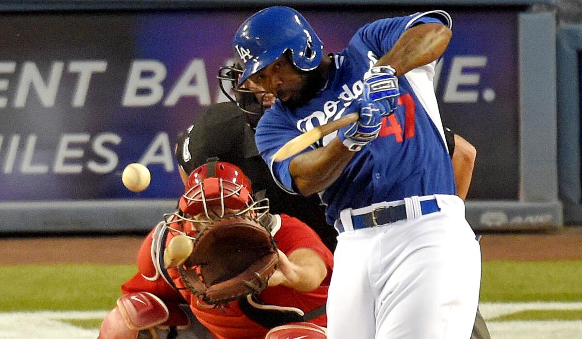 Dodgers second baseman Howie Kendrick breaks his bat as he connects for a single in the fourth inning of the final exhibition game against the Angles on Saturday night at Dodger Stadium.