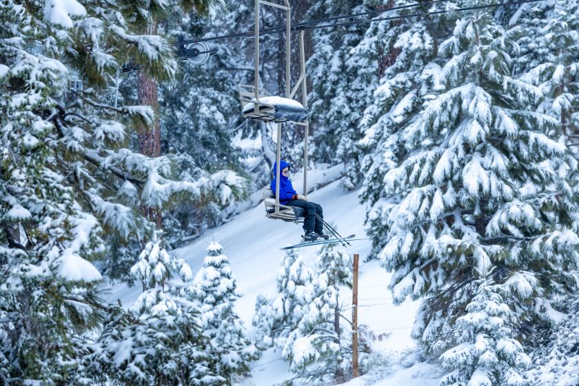 Wrightwood, CA - February 02: Amidst fresh snow from Thursday's storm, a skier takes a scenic chairlift ride at Mountain High Resort in Wrightwood Friday, Feb. 2, 2024. (Allen J. Schaben / Los Angeles Times)