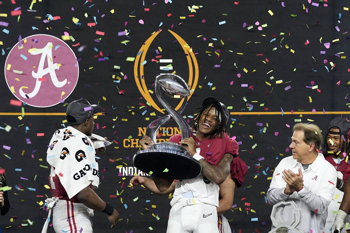 Alabama's Jameson Williams celebrates with coach Nick Saban and Brian Robinson Jr. after beating Cincinnati.