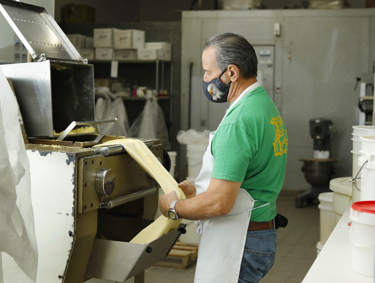 Roberto laminates the dough at Assenti’s Pasta in Little Italy.