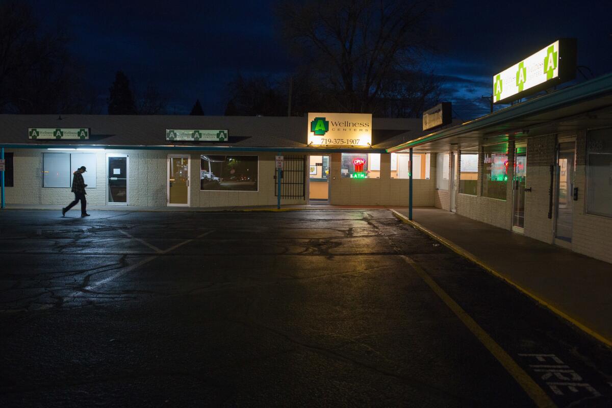 A person walks outside A Wellness Centers marijuana dispensary in Colorado Springs. The dispensary can only sell medicinal marijuana.